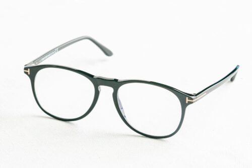 Photo by Saliem Moeslan Minimalist close-up of fashionable black eyeglasses on a white surface.